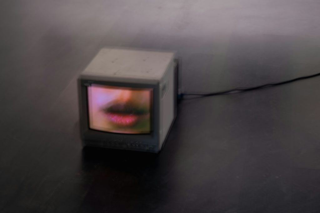 古いビデオデッキとぼやけたモニターに、眠たそうな表情で映る講師の映像